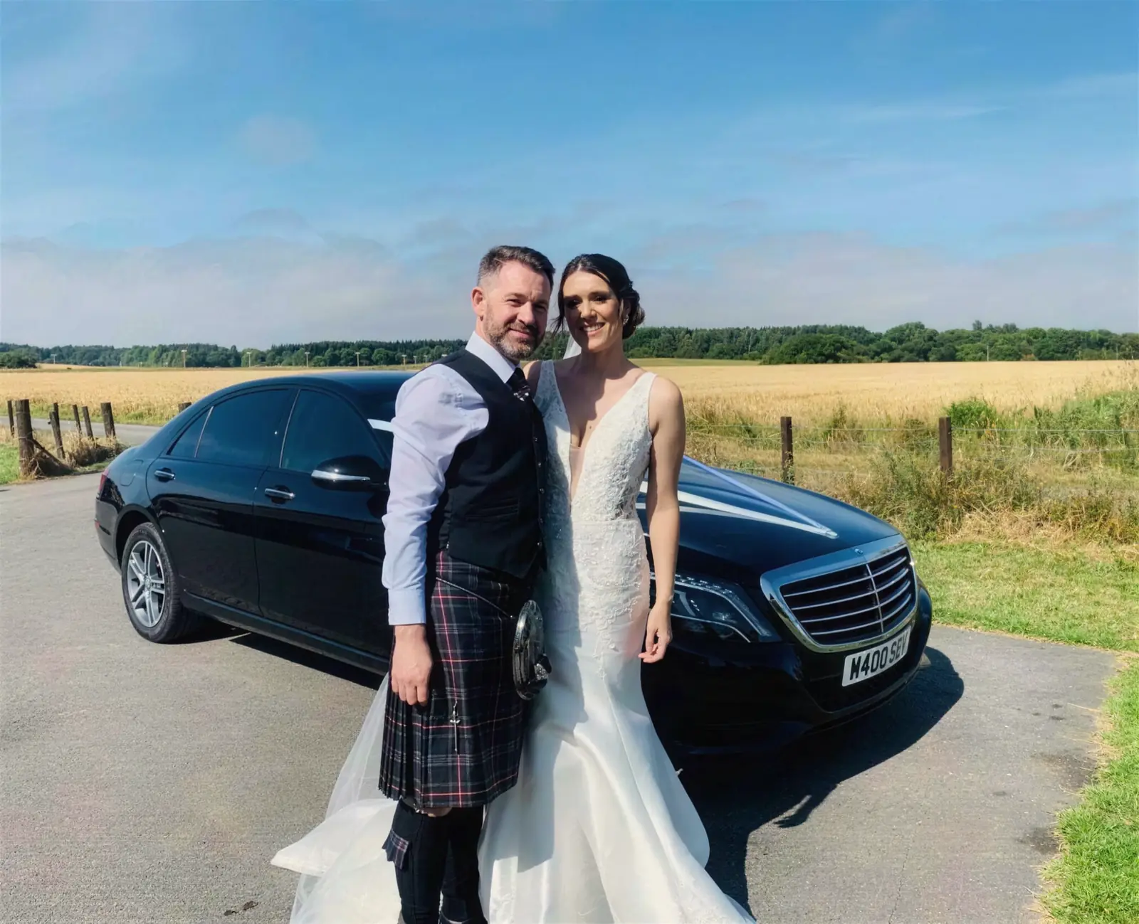 Bride and groom beside a Speyside Executive Hire Mercedes
